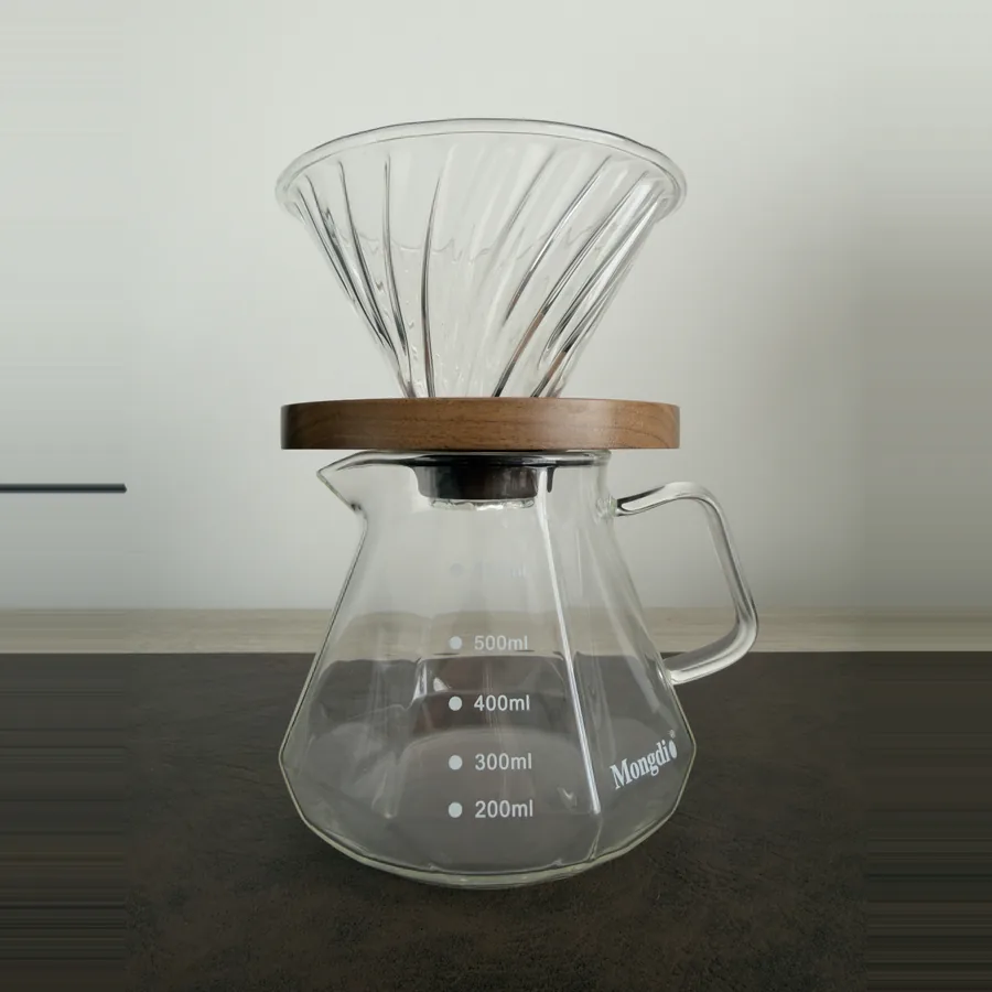 Cono de vidrio para café de goteo sobre una jarra Mongdio de vidrio.