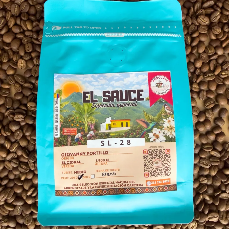 Bolsa celeste de Café SL-28, de la línea El Sauce, sobre granos de café tostado.